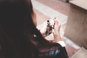 Jeune femme remplissant sa cigarette eletronique