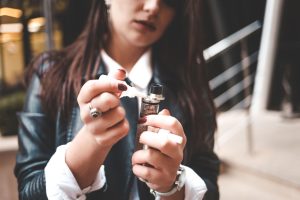 Jeune femme remplissant sa cigarette électronique de e-liquide