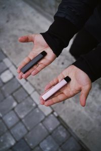 Personne tenant une cigarette électronique dans chaque main
