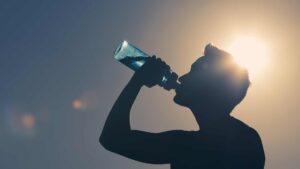 Homme qui boit de l'eau dans une gourde