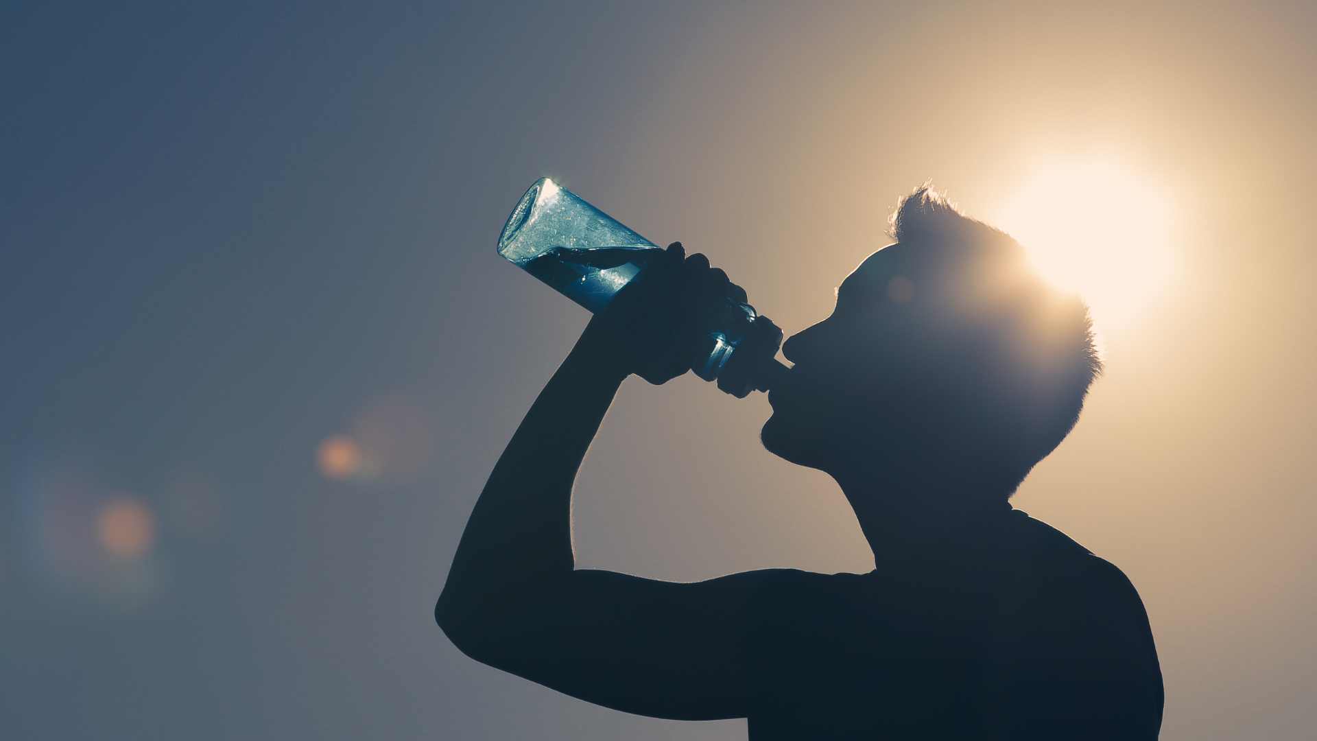 Homme qui boit de l'eau dans une gourde 