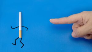 Homme qui pointe du doigt une cigarette